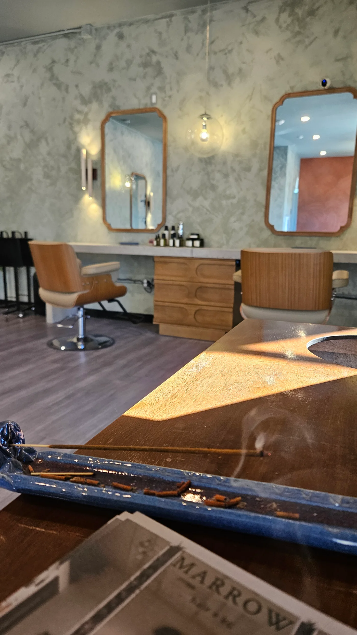 Your chair at Marrow Hair Collective, with wood-framed mirrors and warm natural light